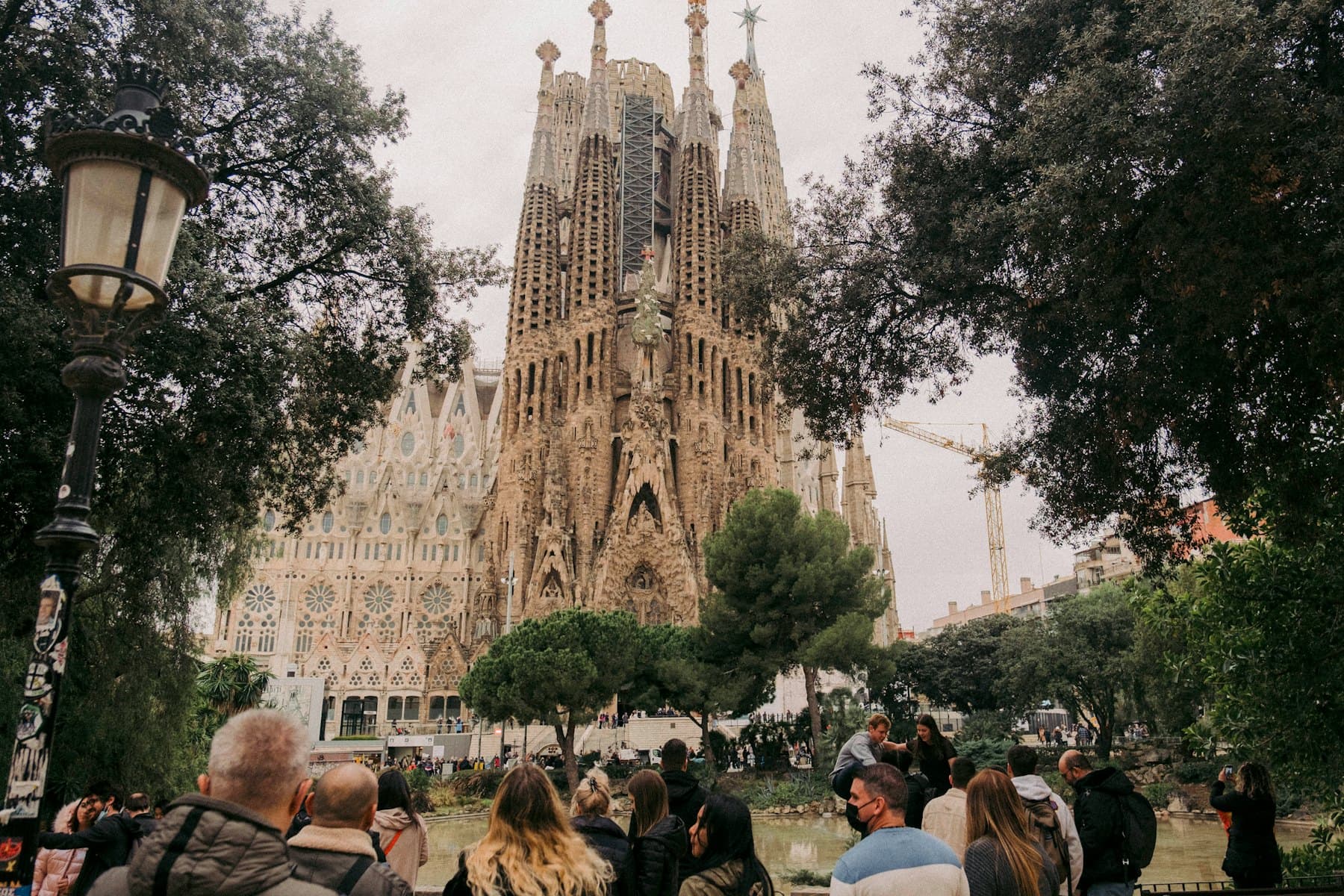 Visitors crossing an open square in front of a Modernista façade in Barcelona