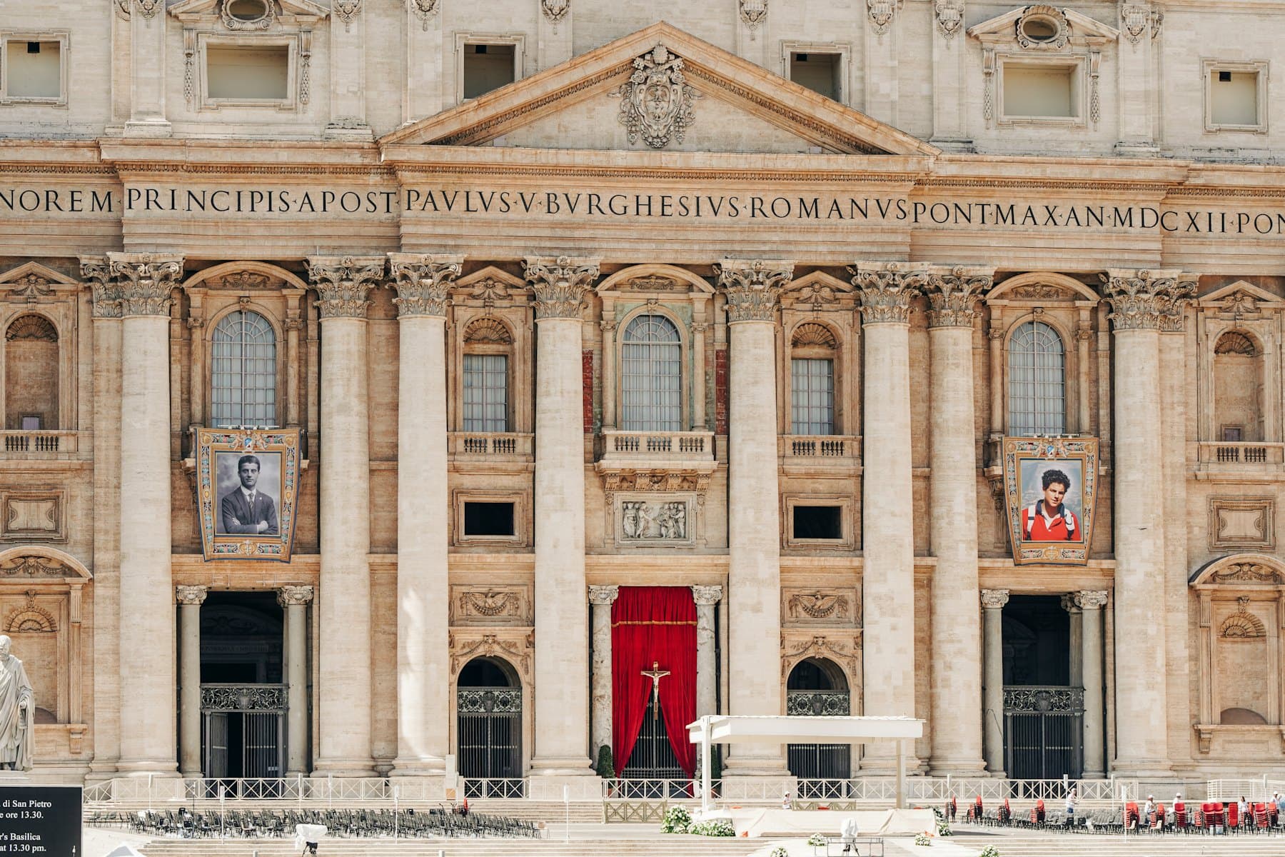 The façade of St Peter's Basilica in Vatican City, hung with red drapery